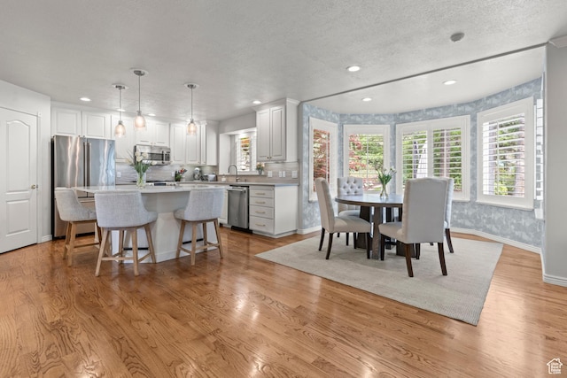 3330 N 175 W, North Ogden, UT 84414 - kitchen with appliances with stainless steel finishes, recessed lighting, a kitchen island, a breakfast bar area, and white cabinetry