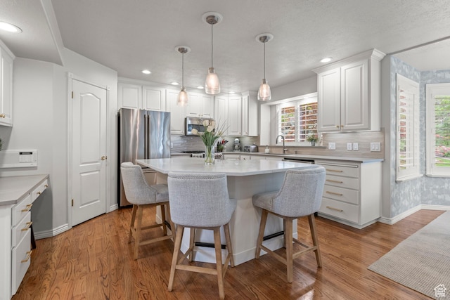 3330 N 175 W, North Ogden, UT 84414 - kitchen with appliances with stainless steel finishes, a sink, baseboards, a center island, and white cabinetry