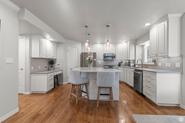 3330 N 175 W, North Ogden, UT 84414 - kitchen featuring appliances with stainless steel finishes, a sink, white cabinetry, a breakfast bar, and tasteful backsplash