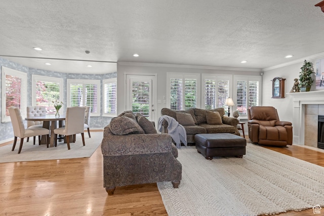 3330 N 175 W, North Ogden, UT 84414 - living area with a textured ceiling, crown molding, a tile fireplace, light wood-style flooring, and recessed lighting