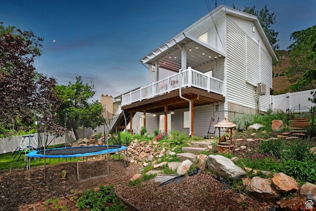 761 N Highland Blvd, Brigham City, UT 84302 - rear view of house with a trampoline, a deck, a fenced backyard, stairs, and a gate