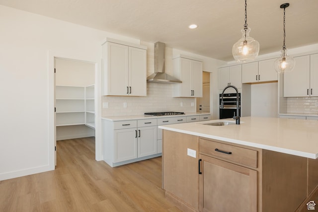 2597 E 360 S Unit 16, Spanish Fork, UT 84660 - kitchen with wall chimney exhaust hood, light wood-type flooring, tasteful backsplash, light countertops, and a sink