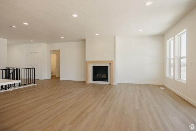 2597 E 360 S Unit 16, Spanish Fork, UT 84660 - unfurnished living room with recessed lighting, light wood-style floors, baseboards, and a tiled fireplace