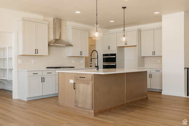 2597 E 360 S Unit 16, Spanish Fork, UT 84660 - kitchen featuring wall chimney exhaust hood, recessed lighting, light wood-type flooring, backsplash, and a center island with sink