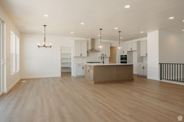2597 E 360 S Unit 16, Spanish Fork, UT 84660 - kitchen featuring wall chimney exhaust hood, a chandelier, recessed lighting, decorative backsplash, and light wood finished floors