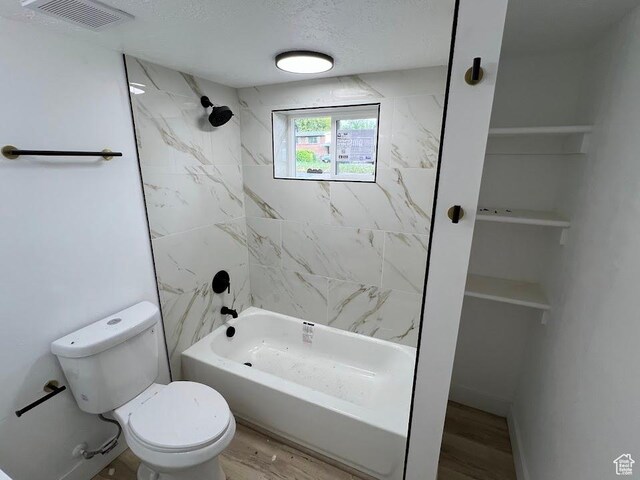 3222 W Tess Ave S, West Valley City, UT 84119 - full bath with toilet, shower / bathtub combination, wood finished floors, and a textured ceiling