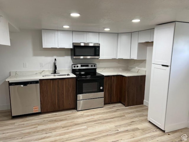 3222 W Tess Ave S, West Valley City, UT 84119 - kitchen featuring appliances with stainless steel finishes, a sink, white cabinetry, light stone counters, and recessed lighting