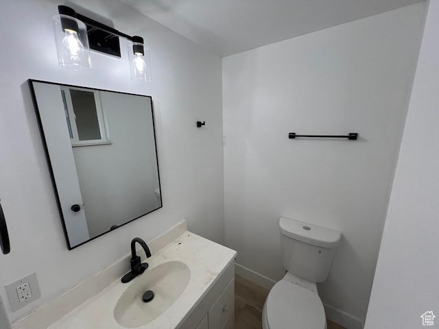 3222 W Tess Ave S, West Valley City, UT 84119 - half bathroom with toilet, vanity, baseboards, and wood finished floors
