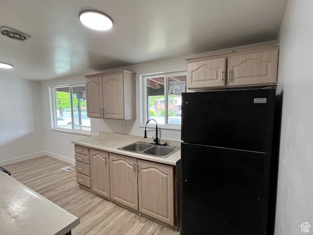 3222 W Tess Ave S, West Valley City, UT 84119 - kitchen with freestanding refrigerator, a sink, light wood-type flooring, light countertops, and light brown cabinets