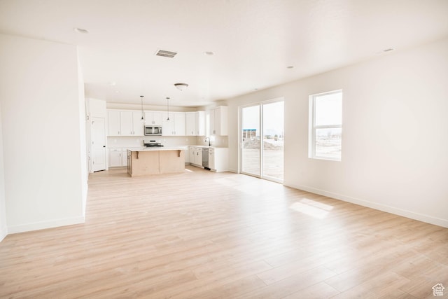1089 E Blackfeet Dr Unit 518, Eagle Mountain, UT 84005 - unfurnished living room with baseboards and light wood-type flooring