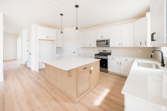 1089 E Blackfeet Dr Unit 518, Eagle Mountain, UT 84005 - kitchen featuring stainless steel appliances, a sink, a center island, light wood-style floors, and a breakfast bar