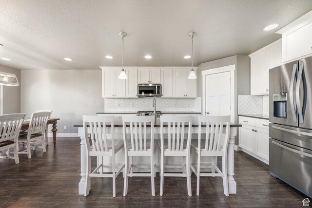 413 W 4100 N, Lehi, UT 84043 - kitchen featuring appliances with stainless steel finishes, recessed lighting, backsplash, an island with sink, and a kitchen breakfast bar