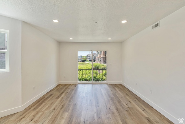 116 E Resaca Unit F3, Midvale, UT 84070 - unfurnished room featuring light wood-type flooring, baseboards, recessed lighting, and a textured ceiling