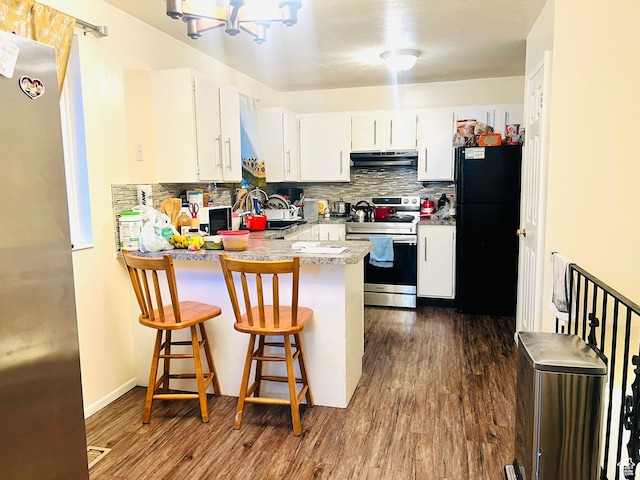 6439 S Clernates Dr, West Jordan, UT 84081 - kitchen with stainless steel appliances, under cabinet range hood, a peninsula, decorative backsplash, and dark wood-type flooring