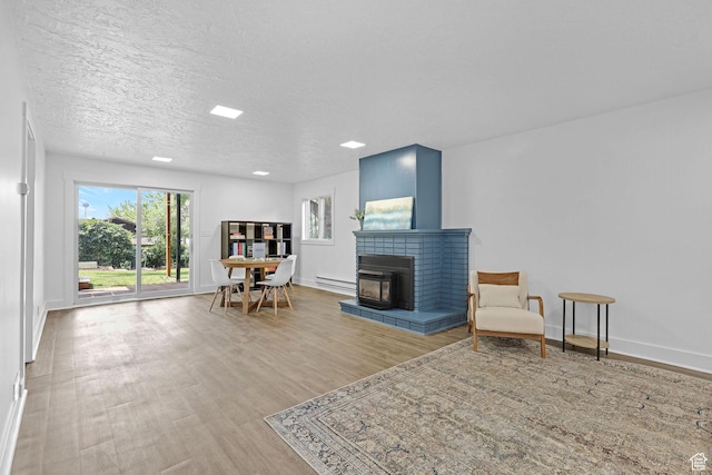 1507 Hudson St, Ogden, UT 84404 - sitting room with a baseboard radiator, wood finished floors, a brick fireplace, baseboards, and recessed lighting