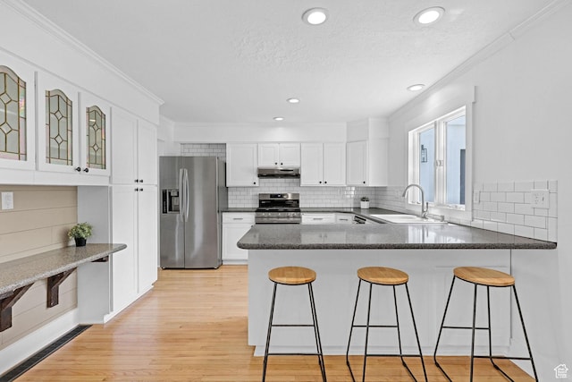 1507 Hudson St, Ogden, UT 84404 - kitchen featuring appliances with stainless steel finishes, a sink, a peninsula, under cabinet range hood, and light wood-type flooring