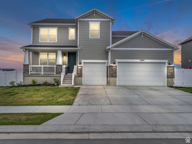 5395 N Cliffrose Dr, Eagle Mountain, UT 84005 - craftsman-style home featuring a porch, concrete driveway, an attached garage, a gate, and stone siding