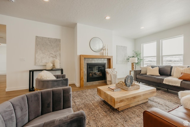 3537 E 1120 S Unit 110, Spanish Fork, UT 84660 - living room featuring wood finished floors, baseboards, a tile fireplace, and recessed lighting