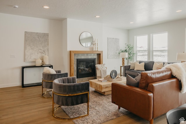 3537 E 1120 S Unit 110, Spanish Fork, UT 84660 - living room featuring wood finished floors, a tile fireplace, recessed lighting, and baseboards