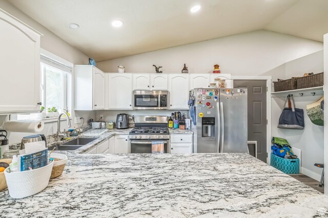 1135 E 220 N, Heber City, UT 84032 - kitchen featuring stainless steel appliances, a sink, vaulted ceiling, light stone counters, and white cabinetry