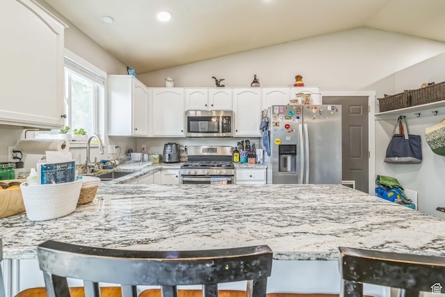 1135 E 220 N, Heber City, UT 84032 - kitchen featuring appliances with stainless steel finishes, a sink, light stone countertops, vaulted ceiling, and white cabinetry