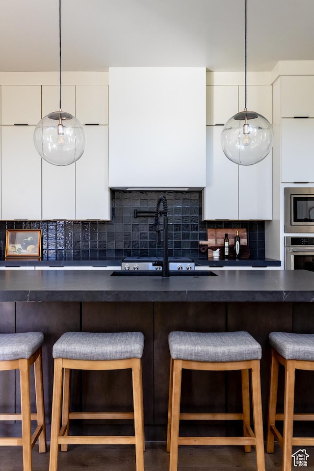 5348 W 10700 N Unit 2, Highland, UT 84003 - kitchen with dark countertops, a sink, and white cabinets
