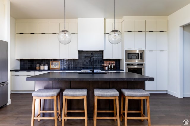 5348 W 10700 N Unit 2, Highland, UT 84003 - kitchen featuring dark countertops, appliances with stainless steel finishes, modern cabinets, a breakfast bar area, and backsplash