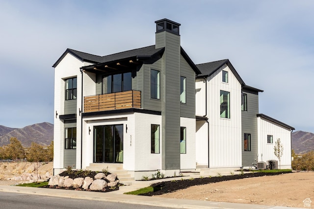 5348 W 10700 N Unit 2, Highland, UT 84003 - view of front facade featuring a balcony, a mountain view, a chimney, central AC unit, and board and batten siding