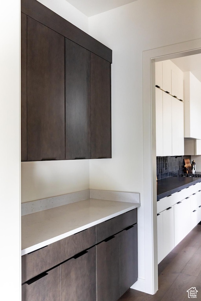 5348 W 10700 N Unit 2, Highland, UT 84003 - kitchen with dark brown cabinetry, modern cabinets, tasteful backsplash, and dark wood finished floors