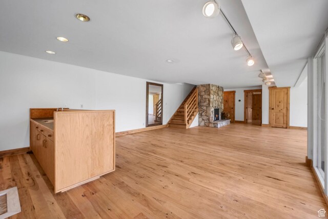 365 Parkview Dr, Summit Park, UT 84098 - unfurnished living room with light wood-type flooring, baseboards, stairs, a fireplace, and a sink