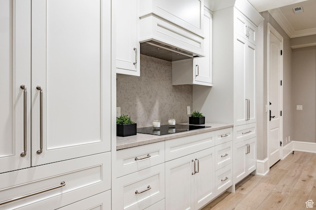 2177 W 9240 S, West Jordan, UT 84088 - kitchen with black electric stovetop, light wood finished floors, decorative backsplash, crown molding, and light countertops