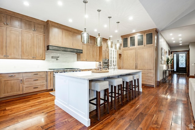 2177 W 9240 S, West Jordan, UT 84088 - kitchen with dark wood-style flooring, custom range hood, a breakfast bar area, a large island with sink, and recessed lighting