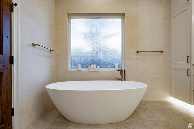 2177 W 9240 S, West Jordan, UT 84088 - bathroom featuring tile walls, a freestanding tub, and tile patterned floors