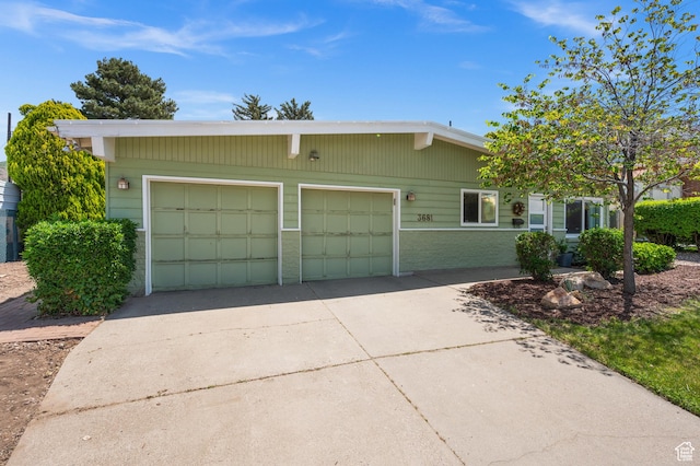 3681 S Terrace Heights Rd, Millcreek, UT 84109 - view of front facade with concrete driveway, brick siding, and an attached garage