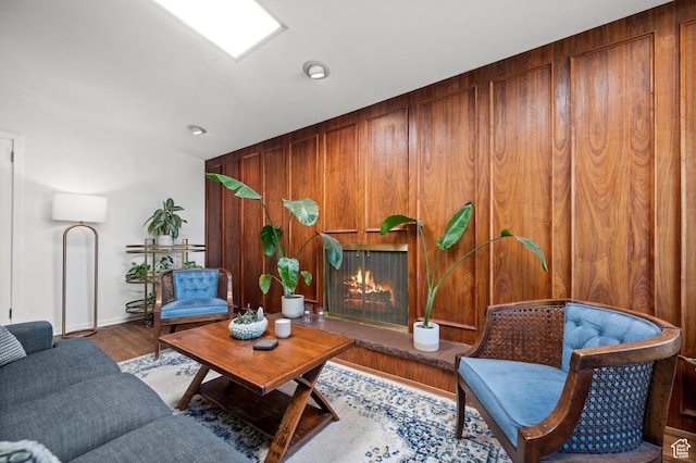 3681 S Terrace Heights Rd, Millcreek, UT 84109 - living room with wood walls, a lit fireplace, baseboards, and wood finished floors