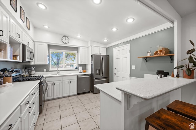 3681 S Terrace Heights Rd, Millcreek, UT 84109 - kitchen with stainless steel appliances, a sink, a peninsula, a breakfast bar area, and white cabinets