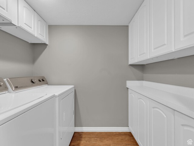 2811 S Filmore St, Salt Lake City, UT 84106 - laundry room featuring washing machine and clothes dryer, cabinet space, baseboards, and wood finished floors