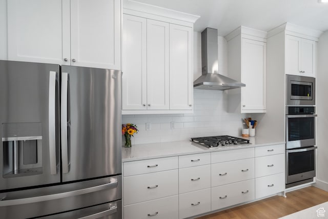 2447 W Santa Fe Dr, Mapleton, UT 84664 - kitchen with stainless steel appliances, wall chimney range hood, light countertops, white cabinets, and backsplash