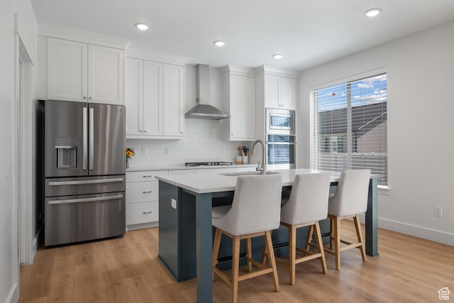 2447 W Santa Fe Dr, Mapleton, UT 84664 - kitchen featuring stainless steel appliances, wall chimney range hood, a sink, an island with sink, and backsplash