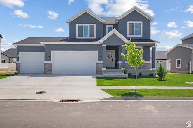 2447 W Santa Fe Dr, Mapleton, UT 84664 - view of front of home featuring a front lawn, stone siding, driveway, and stucco siding
