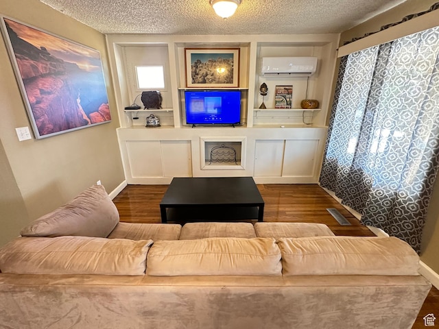 829 E Markea Ave, Salt Lake City, UT 84102 - living area featuring a wall mounted AC, wood finished floors, a textured ceiling, and baseboards