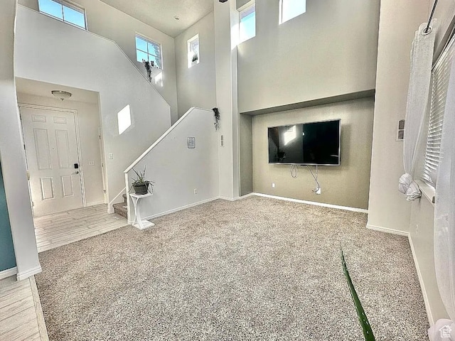 6680 S Leichen Ct, West Jordan, UT 84081 - unfurnished living room featuring a high ceiling, stairs, baseboards, and carpet floors