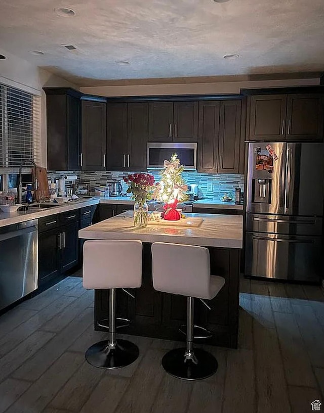 6680 S Leichen Ct, West Jordan, UT 84081 - kitchen featuring stainless steel appliances, dark wood-style floors, a sink, light countertops, and tasteful backsplash