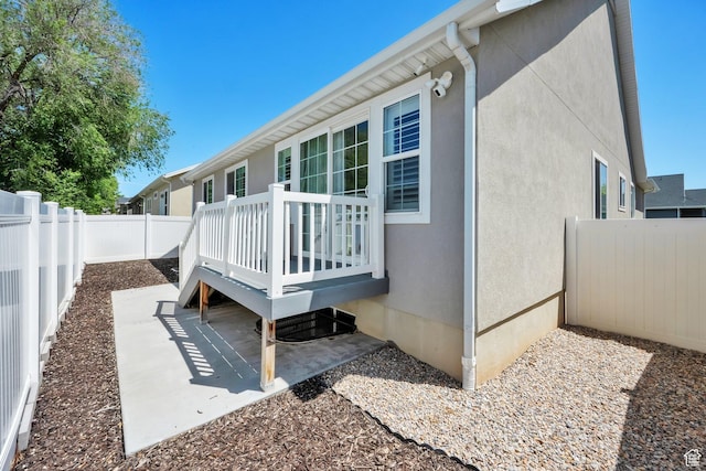257 N 1125 W, Clearfield, UT 84015 - rear view of property featuring a fenced backyard, a wooden deck, stucco siding, and a patio