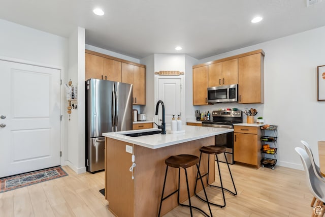 3324 W 3745 S Unit 4065, West Haven, UT 84401 - kitchen featuring appliances with stainless steel finishes, a sink, light wood-style floors, a kitchen bar, and recessed lighting