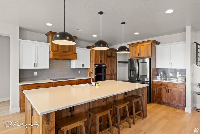 3134 E Blue Heron Dr S, St George, UT 84790 - kitchen with black appliances, a sink, light wood-style flooring, light countertops, and recessed lighting