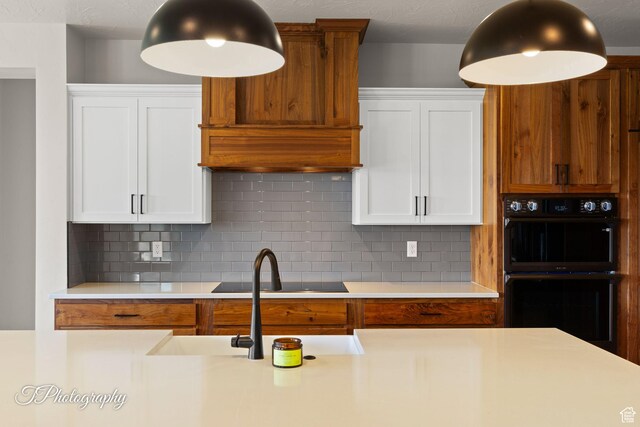 3134 E Blue Heron Dr S, St George, UT 84790 - kitchen featuring black appliances, light countertops, white cabinetry, tasteful backsplash, and a sink