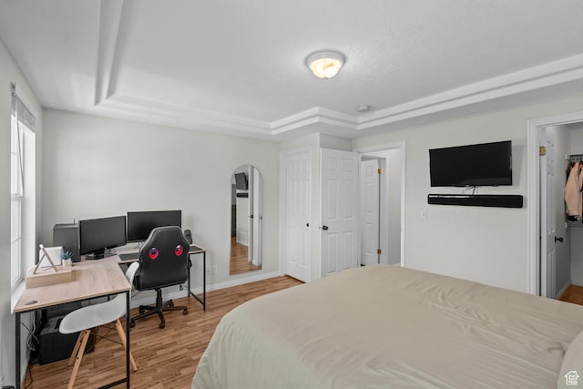 79 W 1970 N, Tooele, UT 84074 - bedroom featuring a tray ceiling, arched walkways, wood finished floors, and baseboards