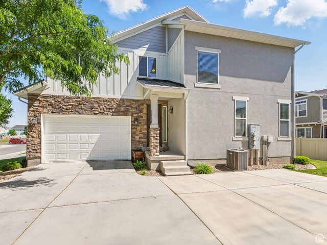 1574 N Cordoba Dr E, Saratoga Springs, UT 84045 - view of front of home with driveway, cooling unit, a standing seam roof, metal roof, and stone siding