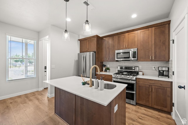 5087 W Rambutan Way S, Jordan, UT 84009 - kitchen featuring stainless steel appliances, a sink, tasteful backsplash, baseboards, and hanging light fixtures